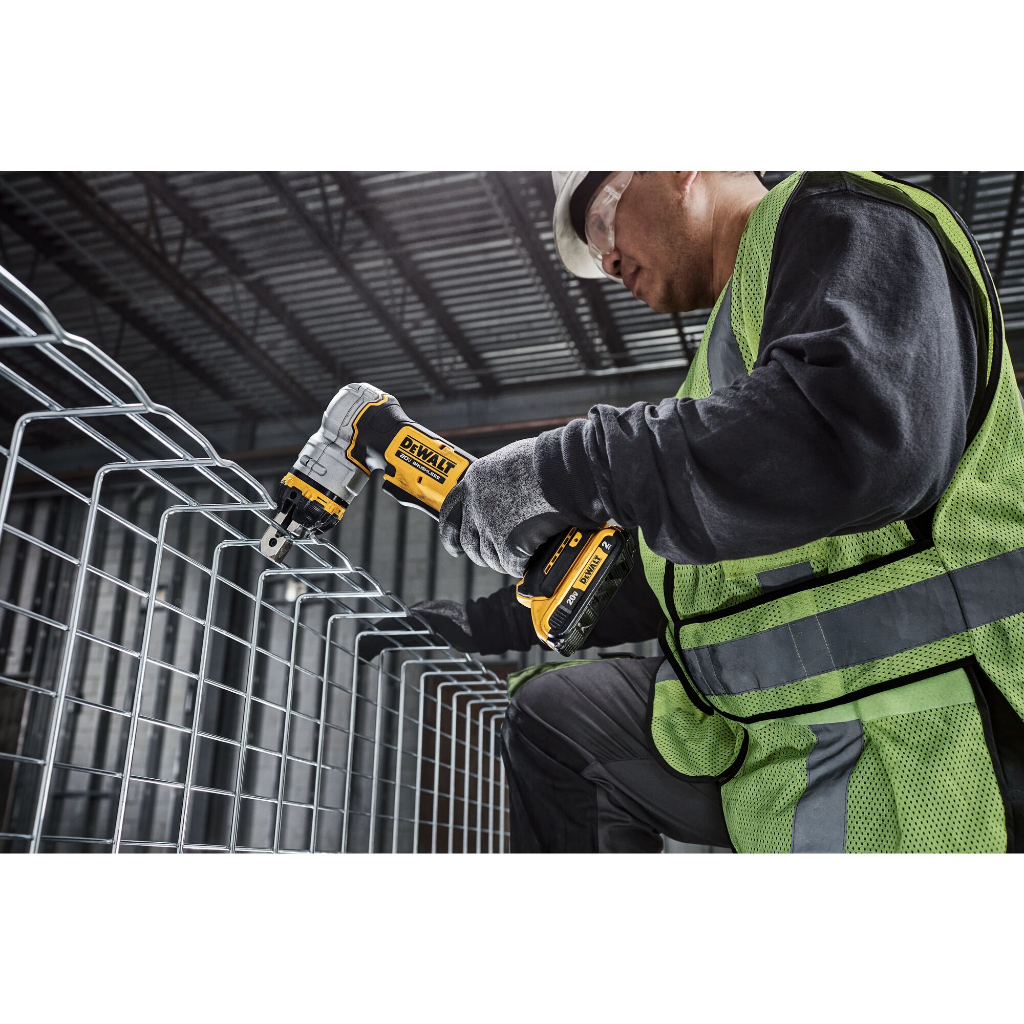 DEWALT Cable Tray Cutter is used by a kneeling tradesman to cut basket tray in a data center.