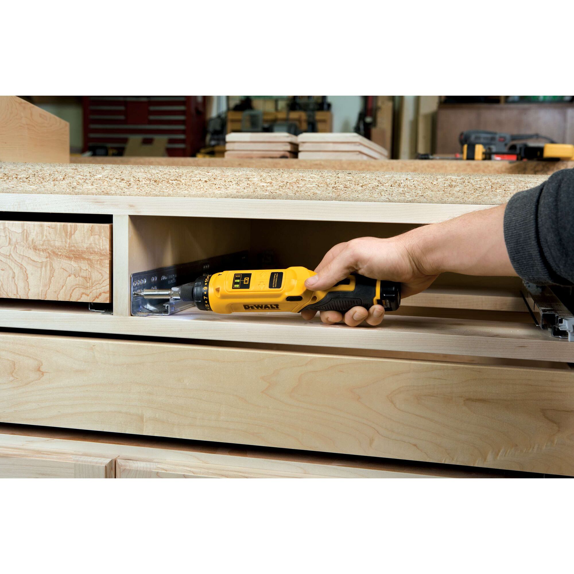 Gyroscopic screwdriver 2 battery being used on glide rail in wooden shelf.