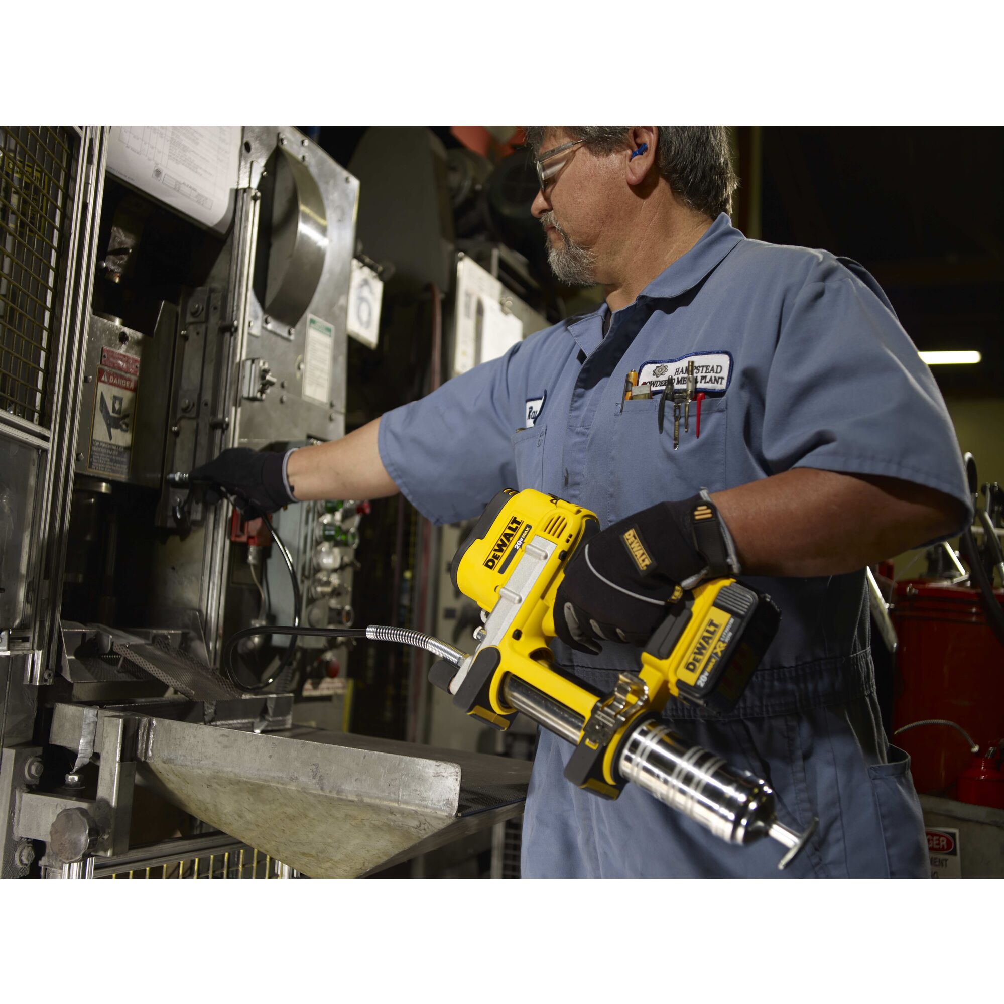 Grease gun being used by a person