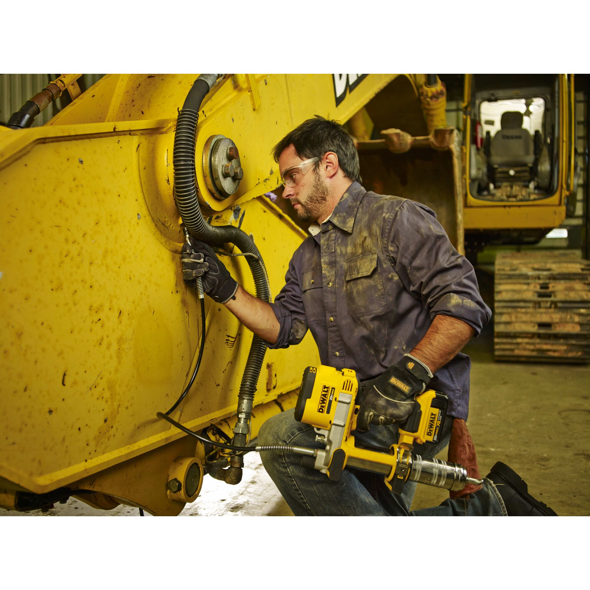 Grease gun being used by a person