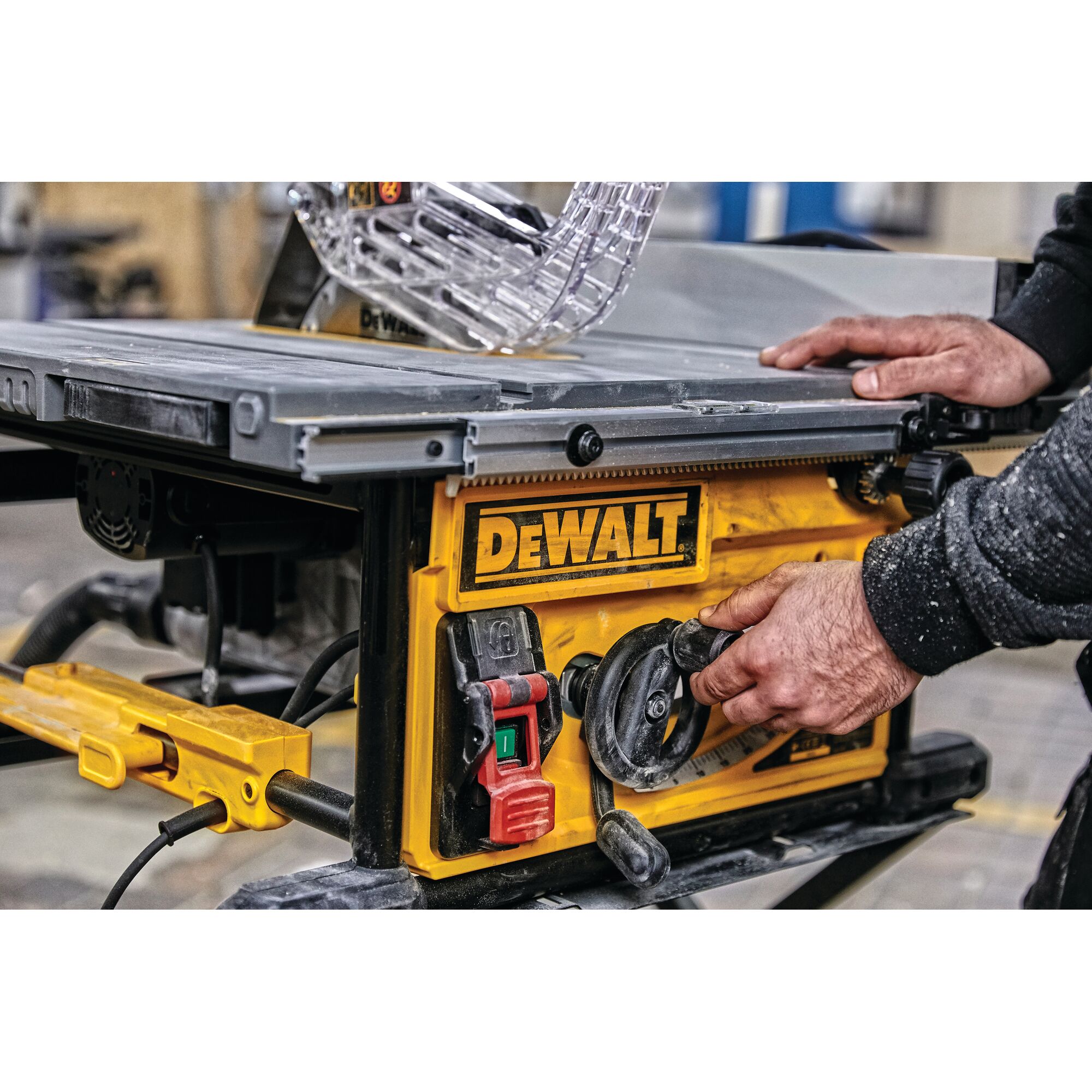 Close-up of a person adjusting the settings on a DEWALT table saw, featuring a yellow control panel with switches and dials in a workshop setting.